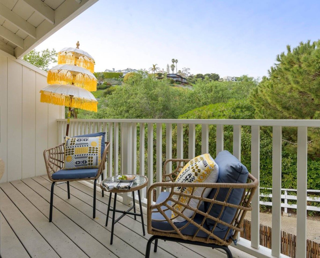 A balcony with wicker furniture and a hanging lamp.