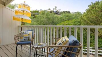 A balcony with wicker furniture and a hanging lamp.
