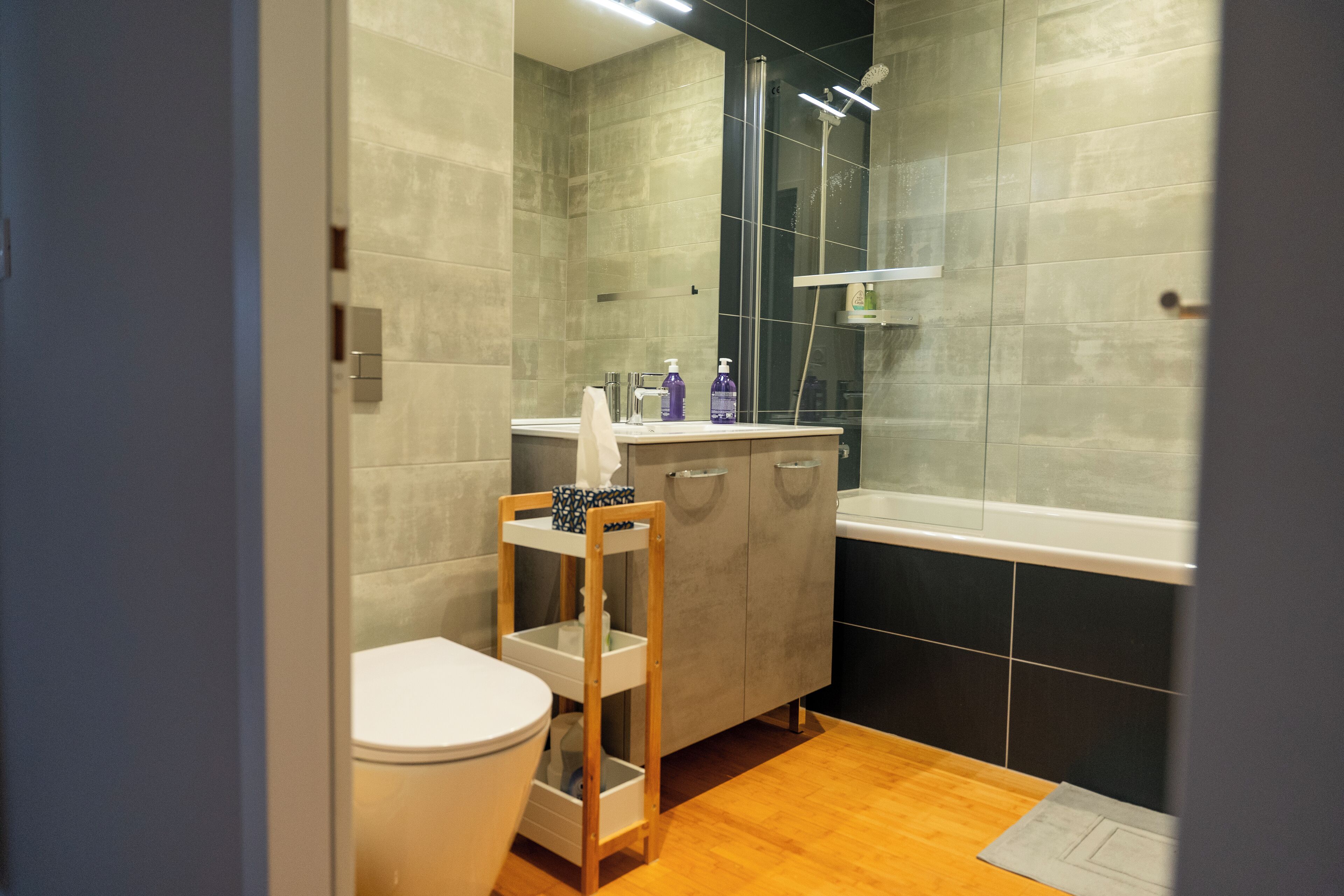 Ein modernes Badezimmer mit Toilette, Waschtisch und Dusche.