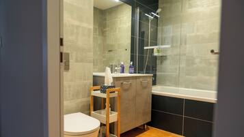 Ein modernes Badezimmer mit Toilette, Waschtisch und Dusche.