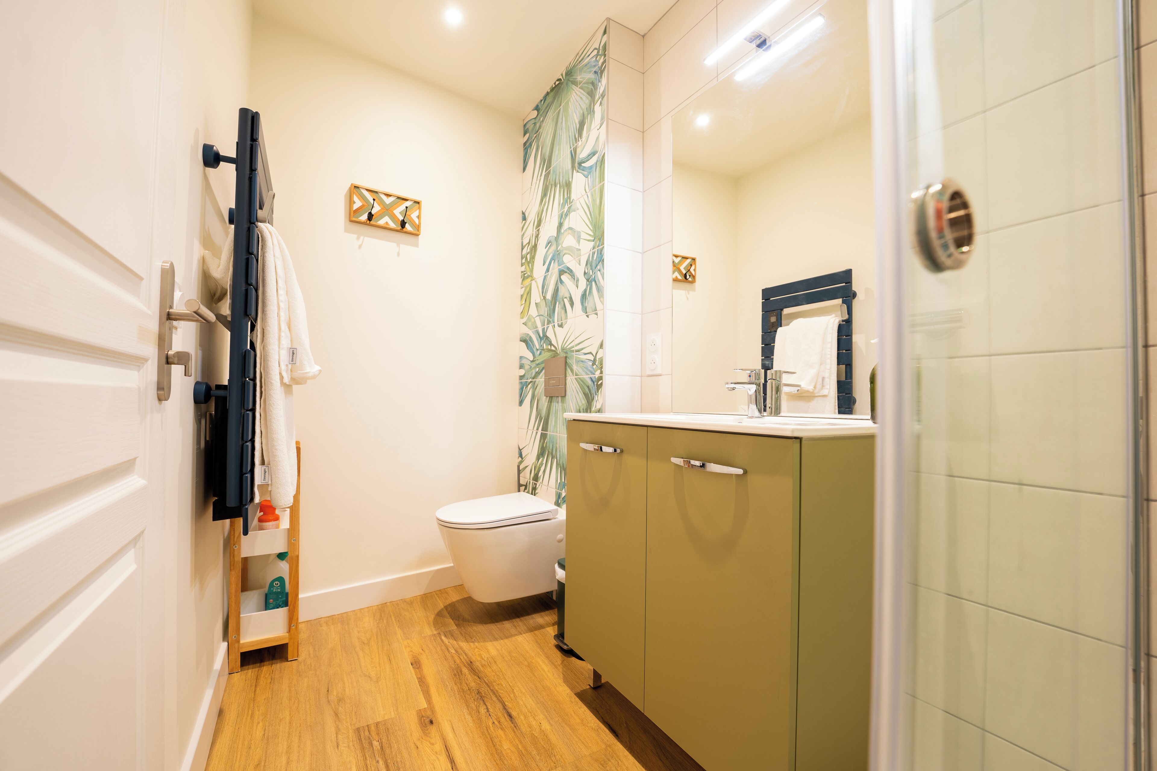 A compact bathroom with a toilet, a sink, and a shower area.