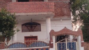 Ein zweistöckiges Gebäude mit Balkon, geschlossenem Eingang und Ziegelverkleidung.