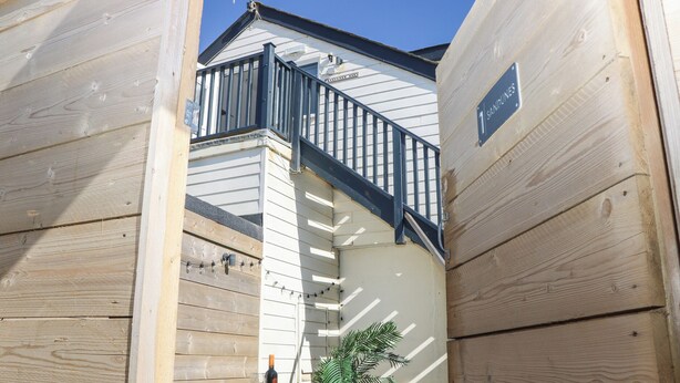 Ein Holzgebäude mit Balkon und einem Schild mit der Aufschrift '1 Sandines'.