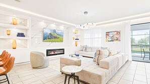 A modern living room with a fireplace, a sofa set, a coffee table, and a TV. - Last Minute Disney! Private Pool, Hot Tub, Game Room & Themed Bedrooms. Book Now! #112977 (Orlando)