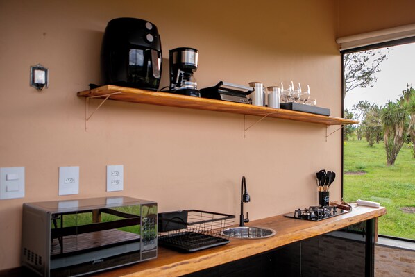 A kitchen with a coffee machine, a toaster, and a sink.