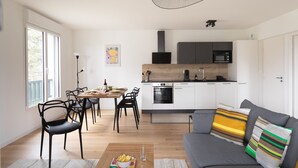 A modern kitchen with white cabinets, a wooden countertop, and a built-in oven.
