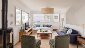 A modern living room with a fireplace, a sofa, a coffee table, and a lamp.