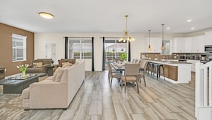 A modern kitchen with white cabinets, a central island, and pendant lighting.