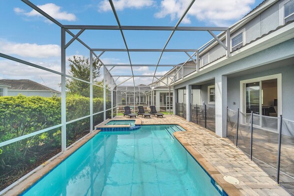 Una piscina con zona cubierta, sillas de descanso y terraza.