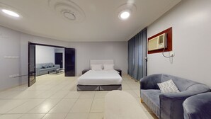 A modern bedroom with a large bed, a sofa, and a TV. - Hotel Al Madinah Hotel Apartments (Madinah)