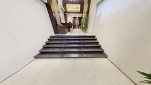 Eine Treppe führt zu einem Aufzug in einem modernen Gebäude.