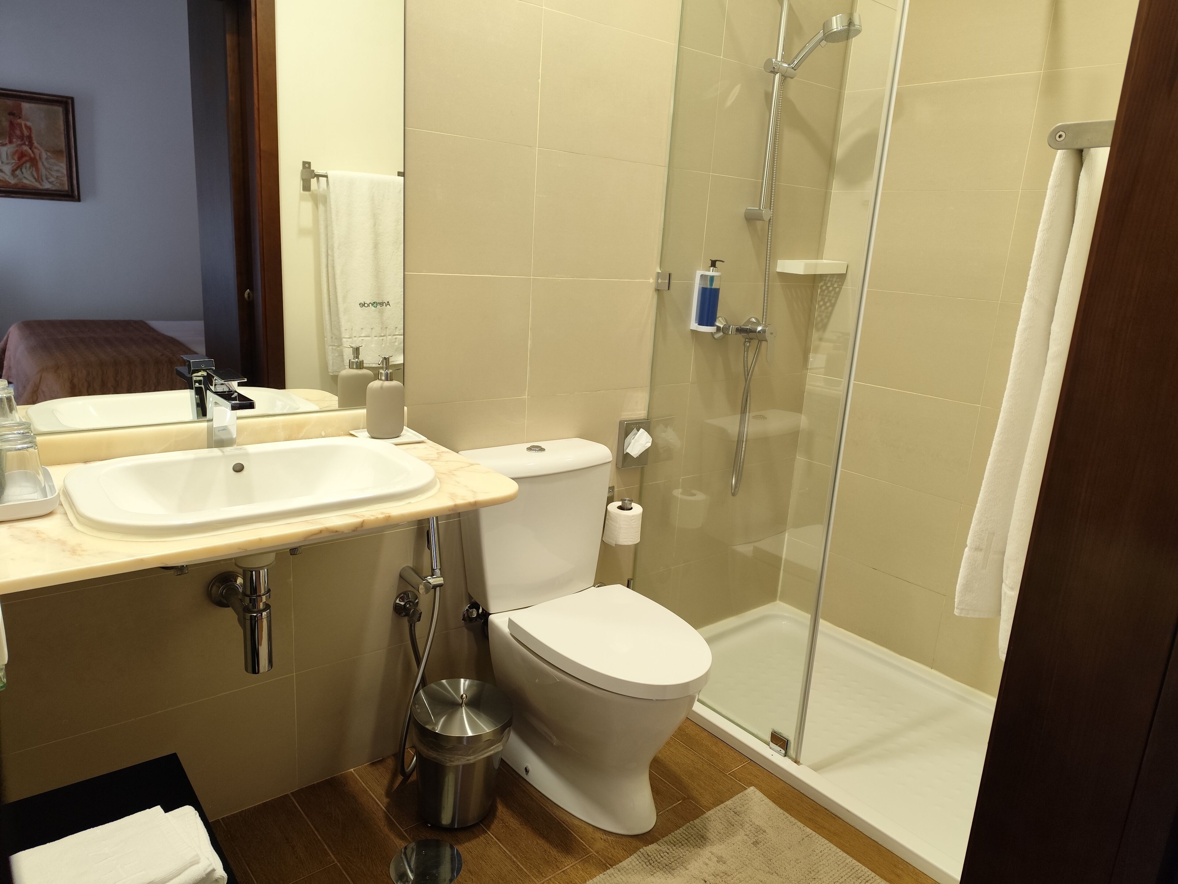 Un baño con lavabo, inodoro y ducha con mampara de vidrio.