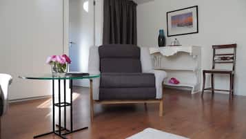 Triple Room, Garden View | Living area | 32-inch flat-screen TV with cable channels, books