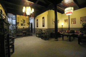 Una habitación tradicional con techo bajo, muebles de madera y obras de arte en las paredes.
