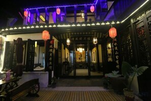 A traditional building with a wooden deck, lanterns, and a covered entrance.