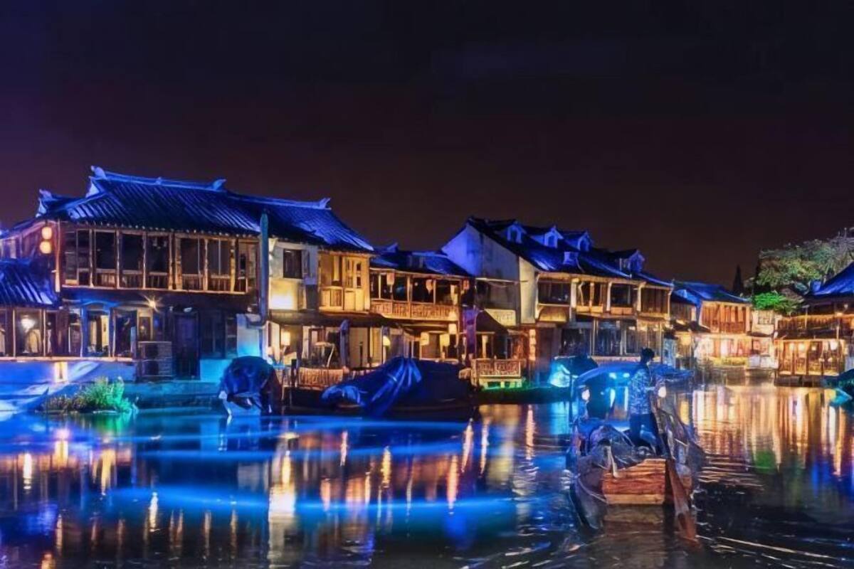 A traditional building with a tiled roof, wooden balconies, and a water body in front.