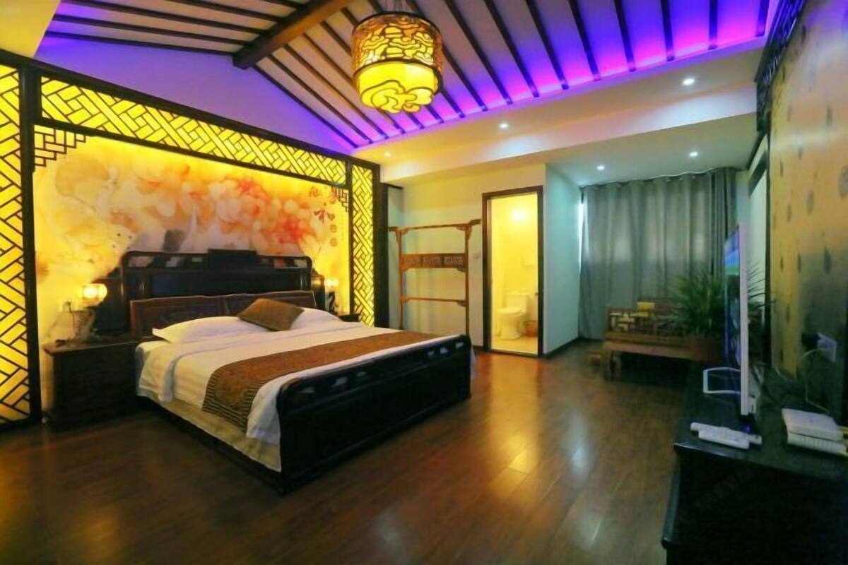 A bedroom with a bed, bedside tables, a desk, and a chair.