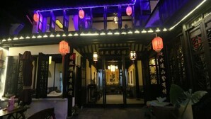 An entrance with traditional Chinese architecture, including wooden doors and lanterns. - Zhouzhuang Qingfeng Mingyuelou Boutique Inn (Kunshan)