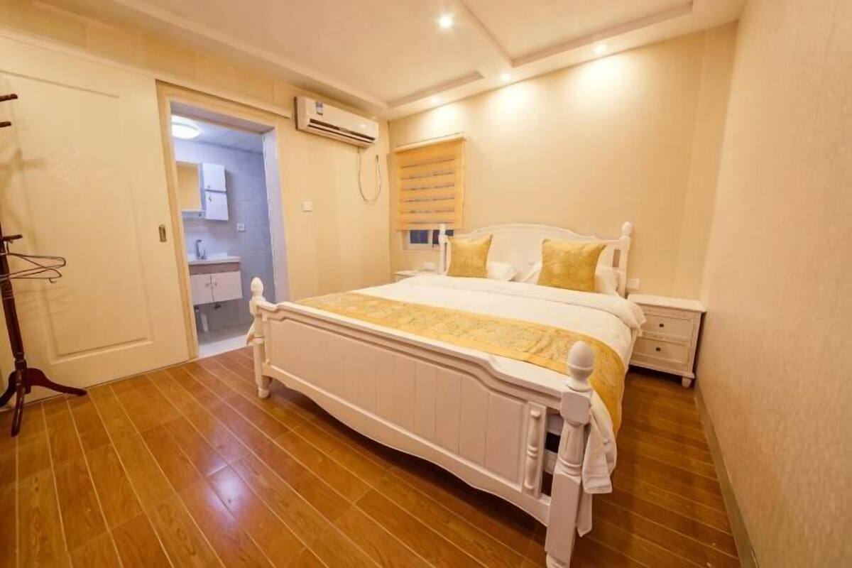 A bedroom with a bed, bedside table, and a wardrobe.