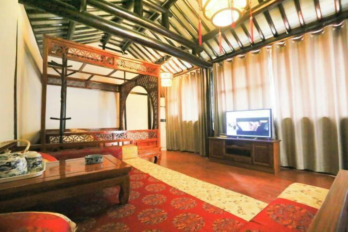 A traditional room with a sofa, a television, and a wooden cabinet.