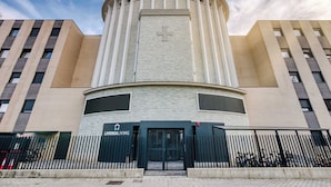 A building with a central tower, a cross on the tower, and a sign that reads "LIVING".