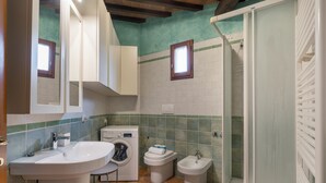 A bathroom with a sink, washing machine, toilet, bidet, and a shower enclosure. - Vigna Nuova Third Floor (Firenze)