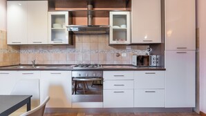 A modern kitchen with white cabinets, a built-in oven, and a microwave. - Vigna Nuova Third Floor (Firenze)