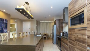 A modern kitchen with a central island, stainless steel appliances, and a wooden accent wall.