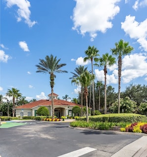 A residential property with a red-tiled roof, palm trees, and well-maintained landscaping. - Themed Bedrooms Near Disney 4BR (Kissimmee)