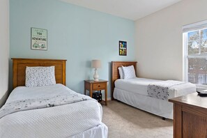 A bedroom with two beds, a nightstand, a lamp, and a window. - Welcoming 4 BR Sleeps 10 Guests Wl2901 (Kissimmee)