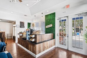 Un comptoir de boulangerie au design en bois, un mur vert et un panneau indiquant la sortie.