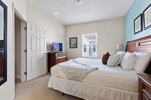 A bedroom with a bed, a dresser, a TV, and a window with blinds. - Welcoming 4 BR Sleeps 10 Guests Wl2901 (Kissimmee)