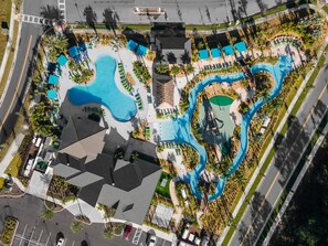Vue aérienne d’un complexe hôtelier doté de plusieurs piscines, d’une plateforme d’atterrissage pour hélicoptères et d’un parking.