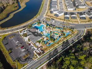 An aerial view of a resort with a large swimming pool, parking area, and adjacent residential buildings. - Sophisticated 6BR at Storey Lake Sl2766 (Kissimmee)