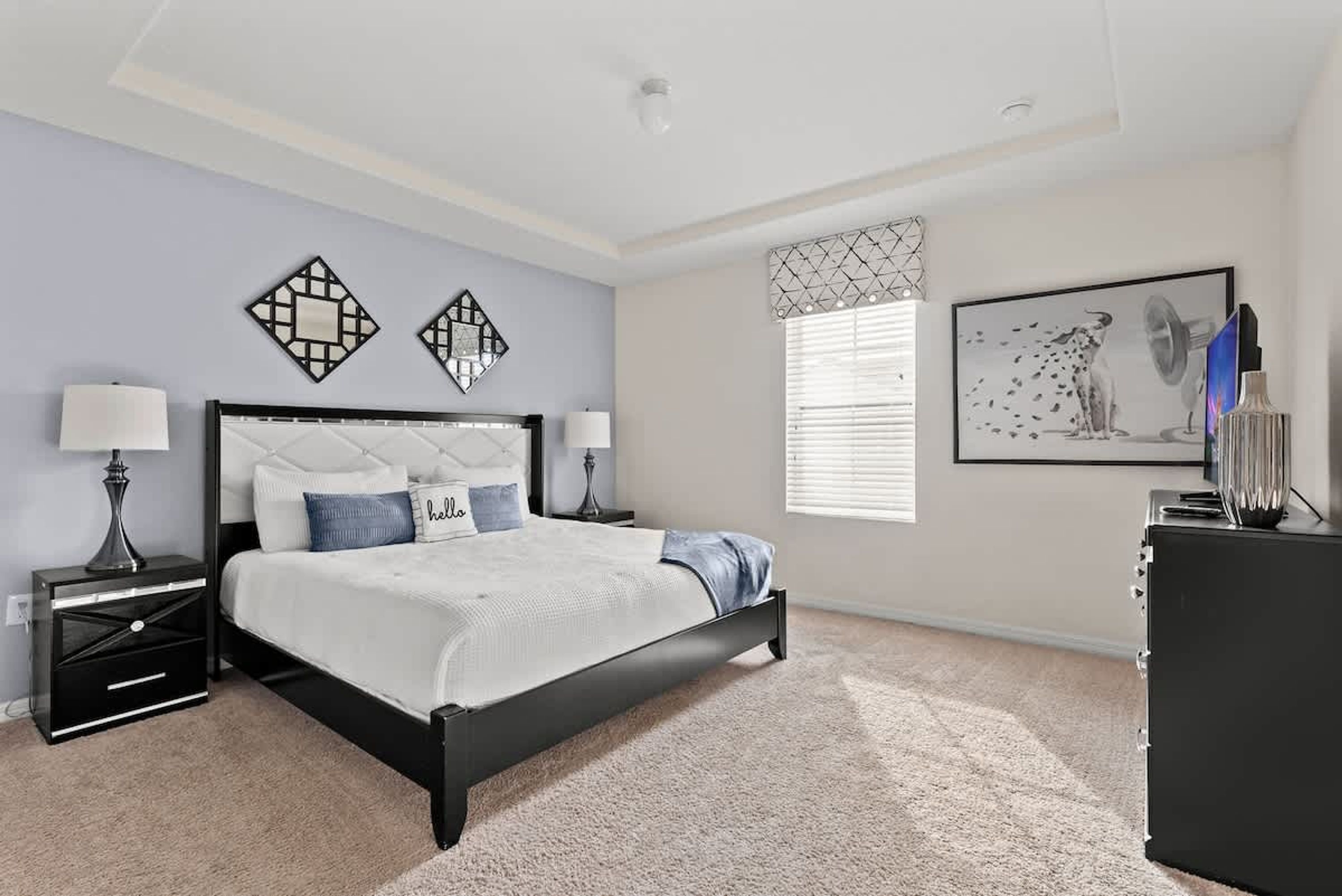 Un dormitorio con cama, mesitas de noche, cómoda y decoración en la pared.