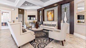 A spacious living room with a modern design, featuring a large sofa set, a coffee table, and a decorative rug.