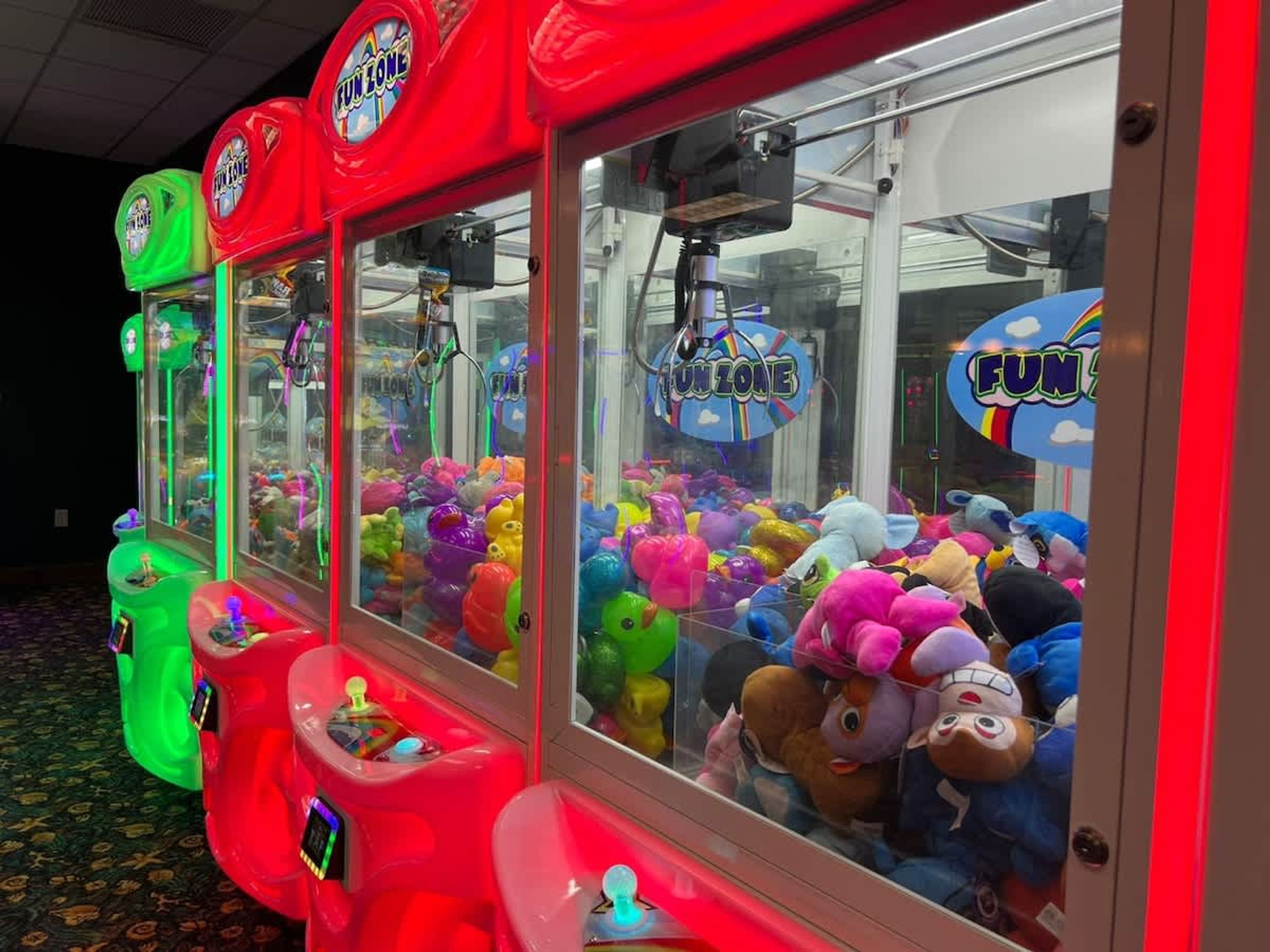 A row of claw machines filled with colorful plush toys.