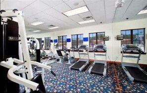 Uma academia com esteiras, elípticos e equipamentos de musculação.