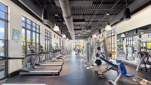 Een sportschool met loopbanden, krachttoestellen en losse gewichten.