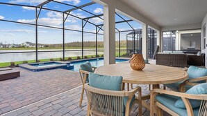 Eine überdachte Terrasse im Freien mit Pool, Sitzgelegenheit und Seeblick.