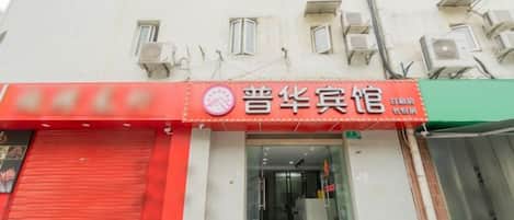 A hotel with a red awning and a sign indicating it is a hotel.