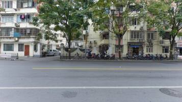 A street with buildings, trees, and parked motorcycles.