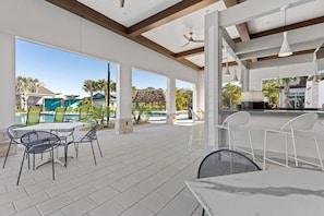 Un espace extérieur aménagé en terrasse, avec des tables et des chaises, une piscine et une vue sur le paysage environnant.