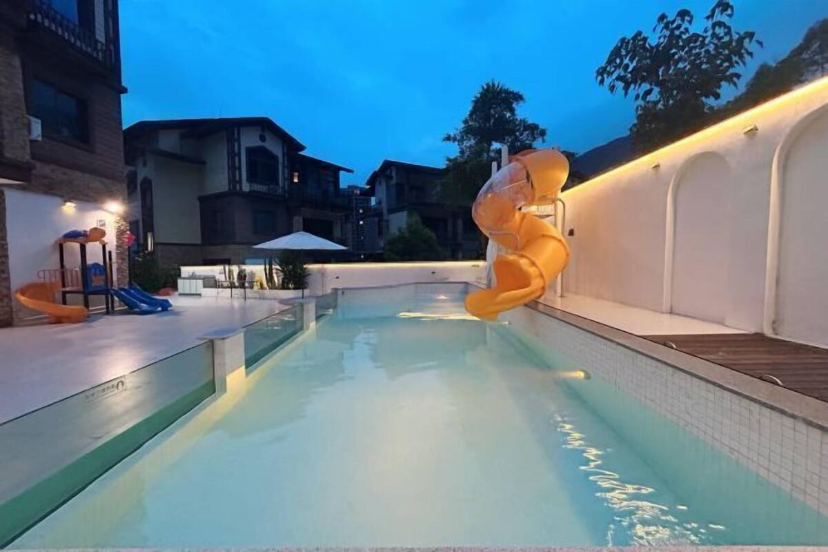 A swimming pool with a slide and a large inflatable figure.