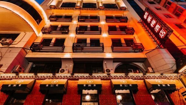 A multi-story building with a row of balconies and a sign indicating a hotel. - Bremen Hotel ( Central Street) (Harbin)