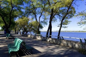 A riverside walkway with benches, trees, and a view of the water. - Bremen Hotel ( Central Street) (Harbin)
