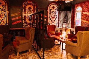 A cozy room with a fireplace, patterned walls, and comfortable seating.