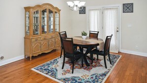 A dining room with a wooden table, four chairs, a cabinet, and a chandelier. - Charming 3-bedroom house with AC, WiFi located in Supply NC near Holden Beach (supply)
