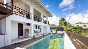 A two-story building with a pool, outdoor seating, and a wooden deck. - Mi Cuna Stays Collection (Jan Thiel)