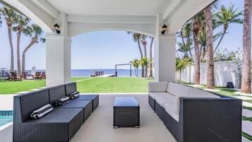 Relax in a spacious outdoor lounge with ocean views, a pool, and comfortable seating areas.